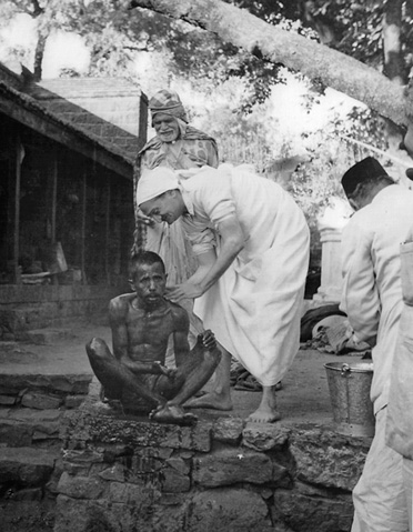 Baba washing Leper with Gadge Maharaj at his side