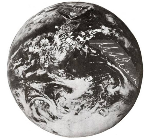 picture of the world from space with small photos of Meher Baba's face  covering it and His signature.