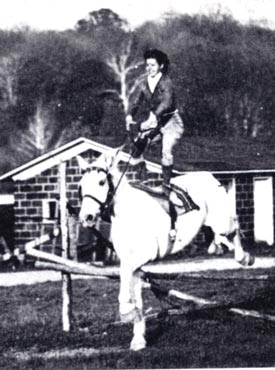 Marguerite Poley doing tricks on white horse